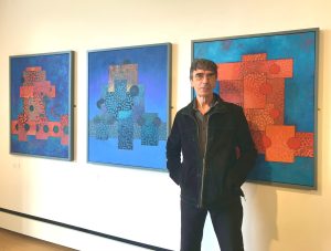 Ceri Pritchard standing in front of his paintings.